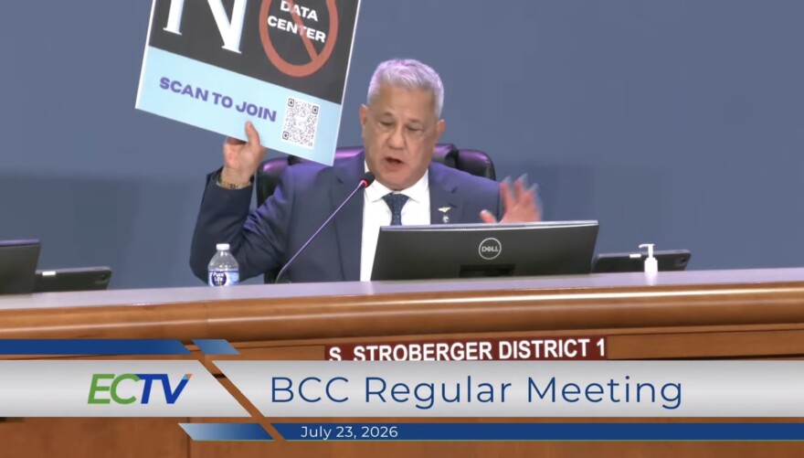Commissioner Steve Stroberger holds 'No data center' sign 