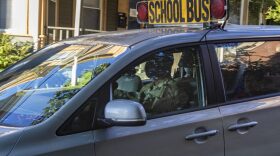A member of the National Guard drives a school bus van in Chelsea, Mass. in October. Massachusetts Governor Charlie Baker activated the Guard to address a shortage of drivers as the school year began.
