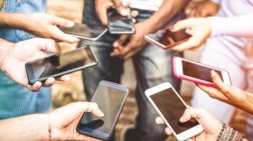 This Adobe stock image shows 7 people holding smartphones in a circle.