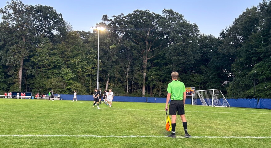 Linesman checks for offside during a free kick.