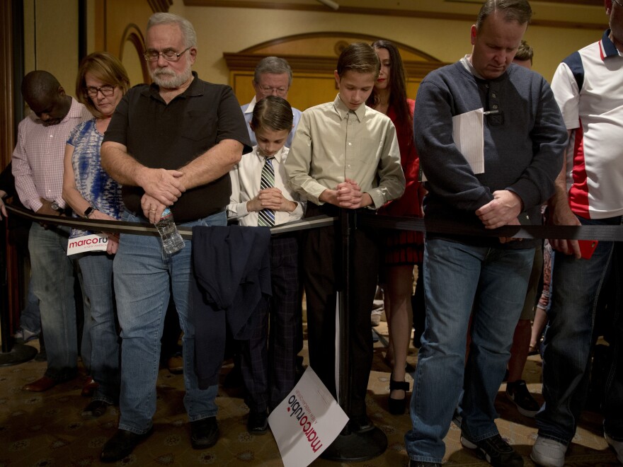 People pray before the start of a rally Sunday with Republican presidential candidate Marco Rubio, in North Las Vegas, Nev.