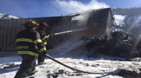 Firefighters spray a semi truck in the aftermath of a head-on collision on I-90 near Missoula, March 20, 2019.