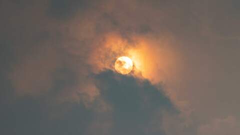 The Sun peeks through the clouds and yellow haze of wildfire smoke over the Boston area on Wednesday morning. (Jesse Costa/WBUR)