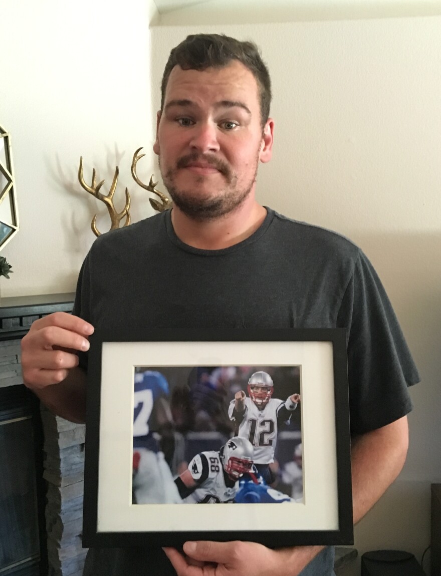 O'Callaghan holds a photo showing him blocking for New England Patriots superstar quarterback Tom Brady.  O'Callaghan was drafted out of college by the Patriots in 2006.