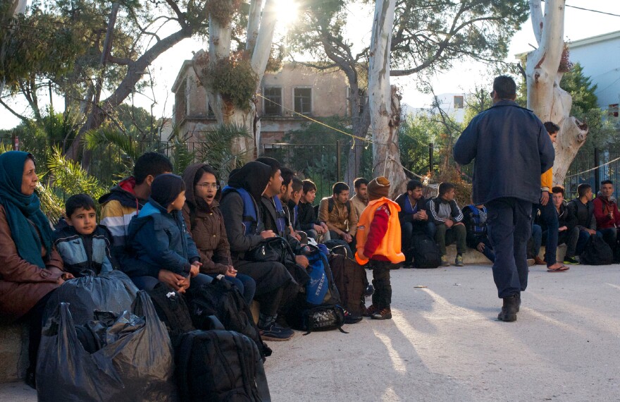 Afghan migrants arrive in the courtyard of the Greek coast guard offices on the Aegean island of Leros. The coast guard and local police fingerprint and register new migrants, most of whom can stay in Greece legally for only a month.