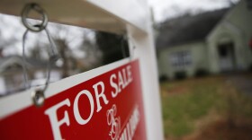 This Jan. 26, 2016 file photo shows a "For Sale" sign hanging in front of an existing home in Atlanta.  Short of savings and burdened by debt, America's millennials are struggling to afford their first homes in the face of sharply higher prices in many of the most desirable cities. Surveys show that most Americans under 35 lack adequate savings for down payments. The result is that many will likely be forced to delay home ownership and to absorb significant debt loads if they do eventually buy. (John Bazemore, File/AP)