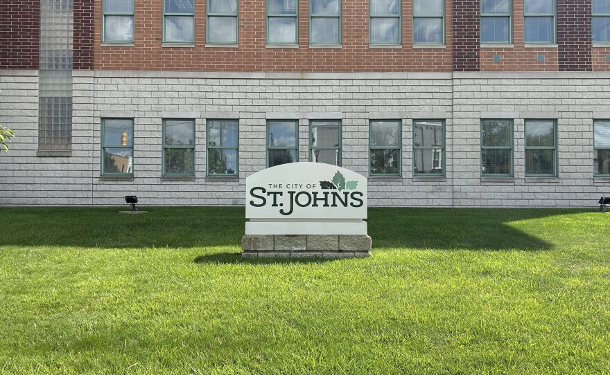A sign reading "The City of St. Johns" on the lawn outside the Clinton County Courthouse
