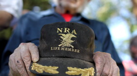 A supporter of Republican presidential candidate Mitt Romney holds an NRA baseball cap during at a campaign rally in Craig, Colo., in May.
