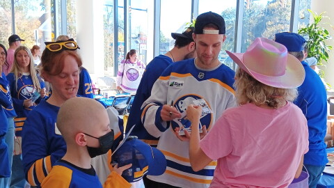 Buffalo Sabres forward Josh Norris sign an autograph for a young fan while Jared, at left front, waits his turn with his mother Amanda at his side. Norris and other Sabres players visited Roswell Park Comprehensive Cancer Institute Monday, Oct. 19, 2026.