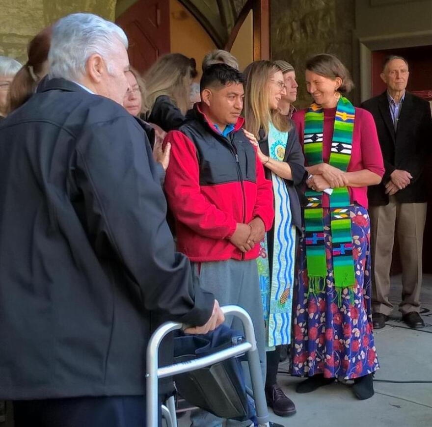 Lucio Perez, center, in a red jacket, is surrounded by local clergy in front of the First Congregational Church in Amherst, Massachusetts in October 2017. 