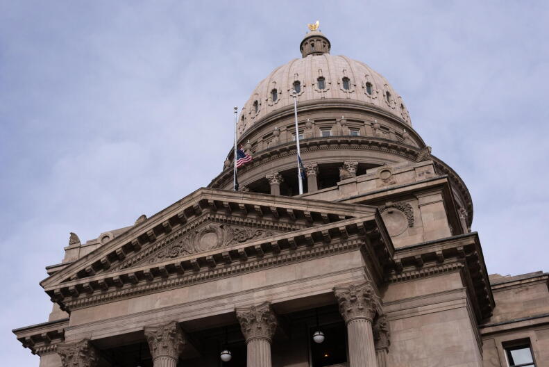 The Idaho State Capitol showing the American flag flying in the wind.