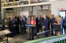 People speaking at a microphone surrounded by Holocaust artifacts