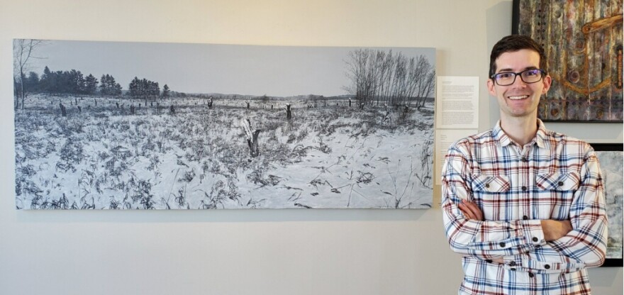 Nik Burkhart with his piece "Among What We Have Lost," which is graphite and acryclic on canvas. (Photo: Ted Carlson)