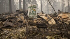 A sign for a recent graduate is bent but not burned in Blue River, Ore., eight days after the Holiday Farm Fire swept through its business district.