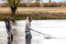 Army veteran Luke Cureton catches a fish as Jacquie Nelson, a guide with Warriors and Quiet Waters, looks on. Warriors and Quiet Waters brings post 9/11 combat veterans to Montana for a therapeutic fly-fishing experience.