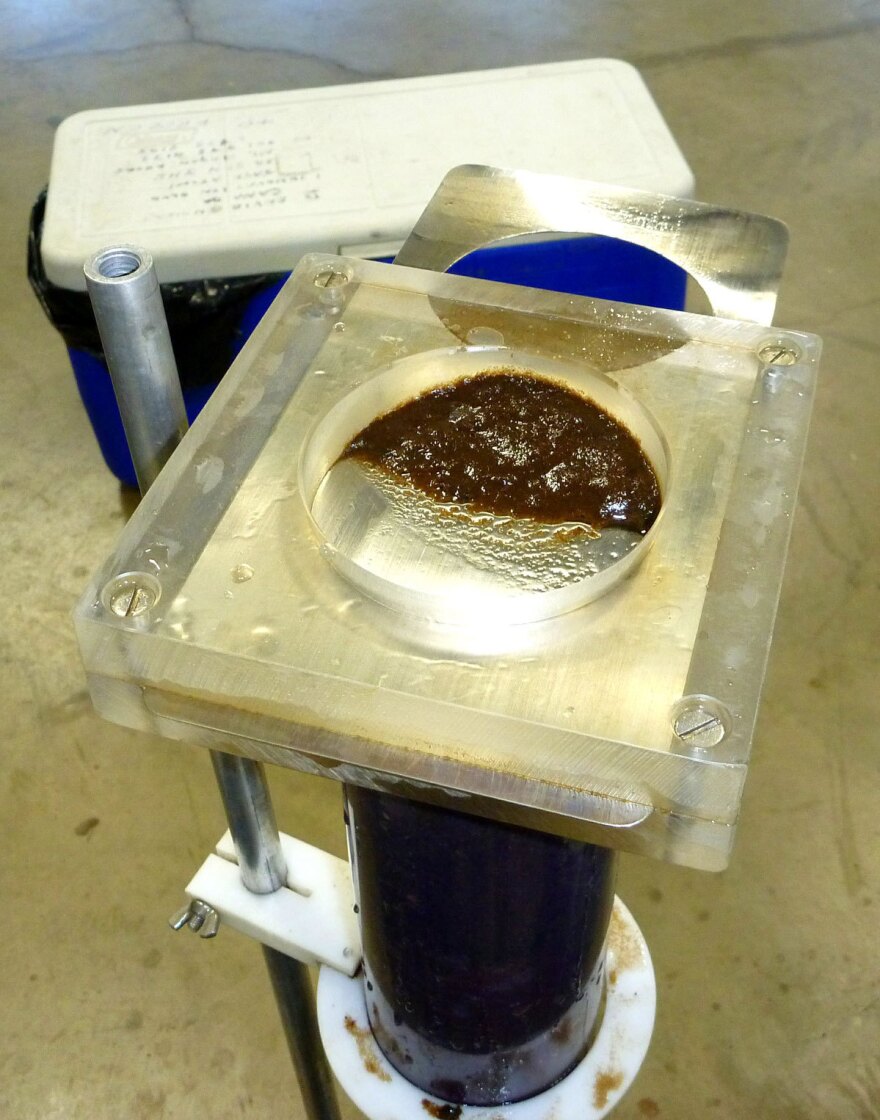 Layers of lake sediment are removed at intervals from a core. In a laboratory, contaminants and biological remains are analyzed from select sediment layers to understand lake history and reconstruct environmental changes that often predate periods of direct monitoring.