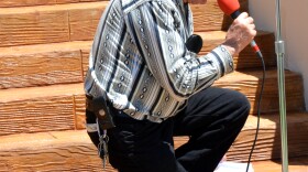 Pastor Eugene Adams kneels on the Delta County Courthouse steps.