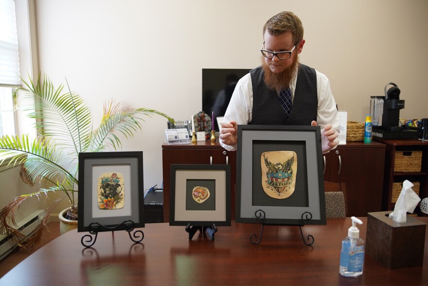 Kyle Sherwood, chief operating officer of Save My Ink Forever, sets up samples of the company's tattoo preservation work at its offices in Northfield, Ohio.