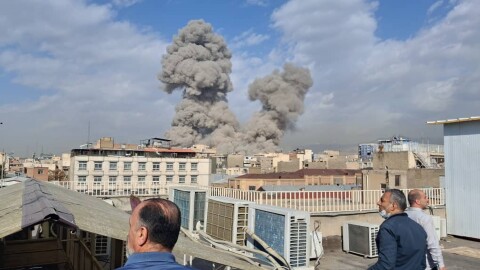 People watch as smoke rises on the skyline after an explosion in Tehran, Iran, Saturday, Feb. 28, 2026.(AP Photo)