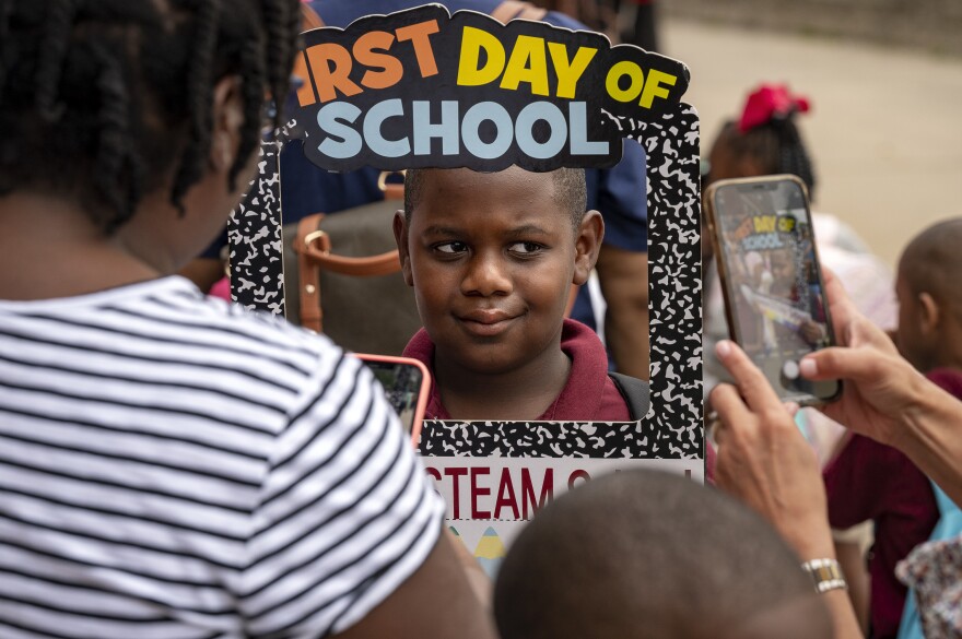 Jerimiah Baugh poses for a photo on his first day of fourth grade. The students and families of Rawson Elementary School in Hartford are greeted with enthusiasm by members of Calling All Brothers.