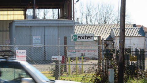 Car driving by closed industrial plant. 