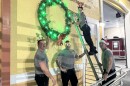 Cape Coral firefighters hang the annual 'Keep the Wreath Green' decoration. If a preventable fire occurs between Dec. 1 and Jan. 1, a green bulb will be changed to red.