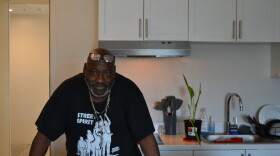 Derrick Hayes stands in the kitchen of his apartment