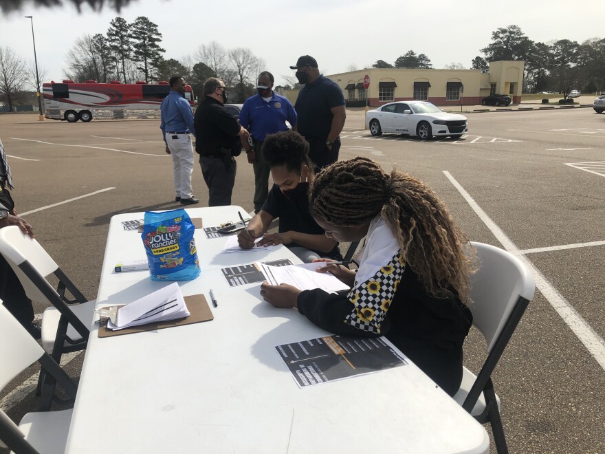 Kierra Jones and Roshuntianna Fairley fill out applications to be correctional officers in the parking lot in Pearl, Miss, March 13, 2021.