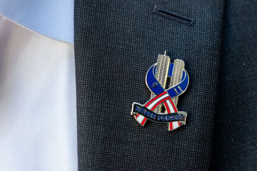 Brett Eagleson, 40, President of 9/11 Justice, wears a 9/11 pinduring a press conference demanding accountability regarding the Kingdom of Saudi Arabia's role in the 9/11 terrorist attacks, Tuesday, Sept. 8, 2026, in New York. (AP Photo/Adam Gray)
