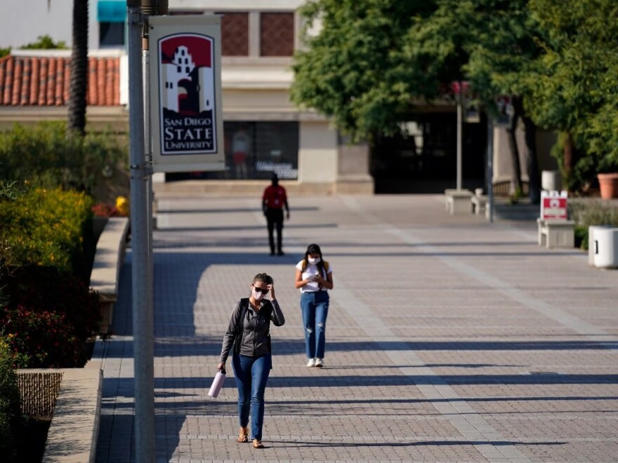 In this Sept. 2, 2020 file photo people walk on campus at San Diego State University, in San Diego.