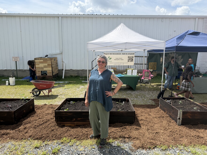Beth Dryer, founder and executive director of the 757 Creative Reuse Center, stands in front of newly installed gardening beds during the "Back to Our Roots" community event along Colley Avenue.