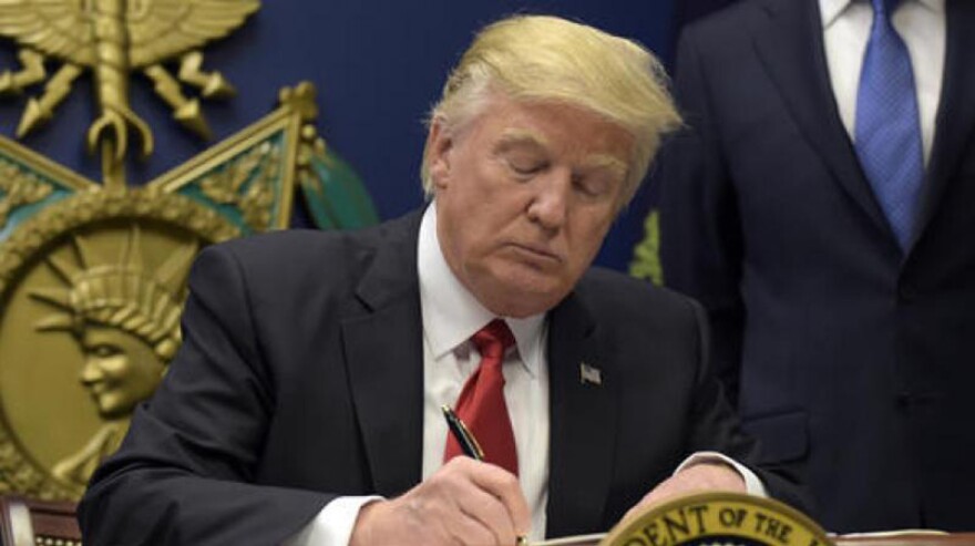 President Donald Trump signs an order suspending tariffs on steel and aluminum imports in March 2018.