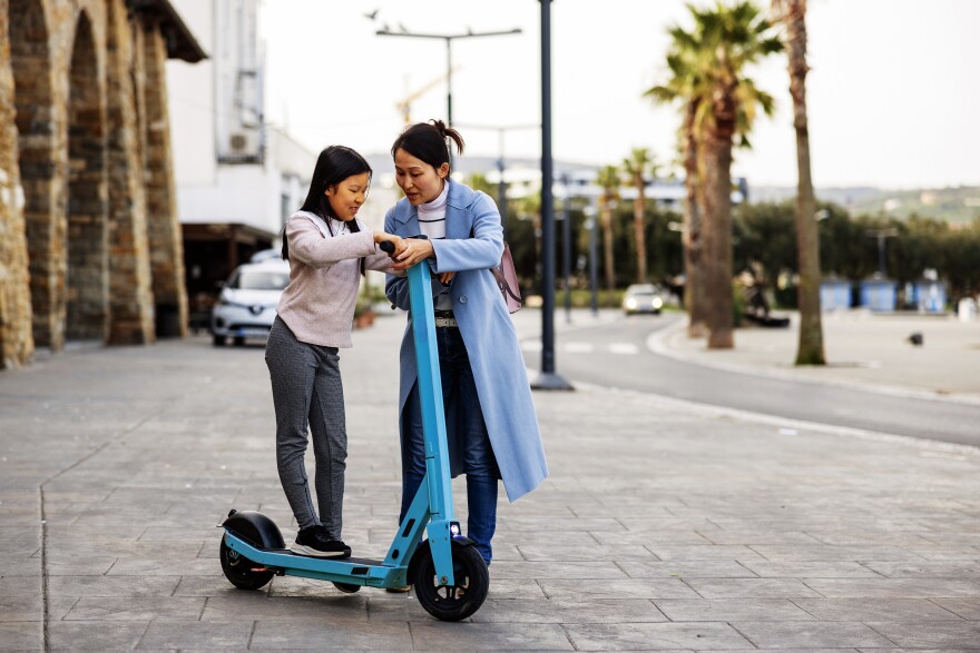 A mother shows her young daughter how to use an electric scooter. Connecticut Children's Emergency Department treated a record number of electric scooter-related trauma cases over the first weekend of August this year.