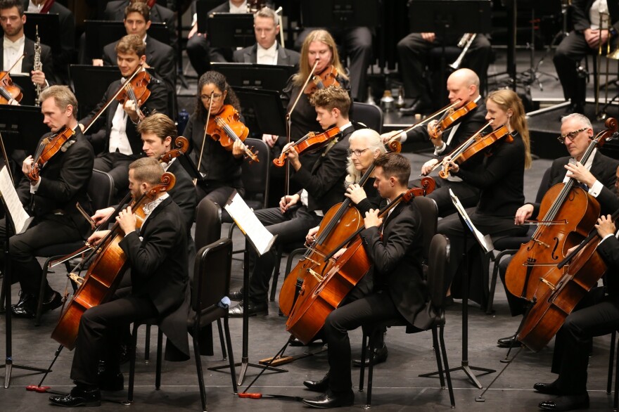 The strings section of The Florida Orchestra looks at their sheet music while playing.