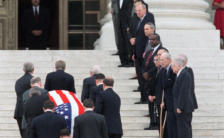 Past and present members of the Supreme Court, right, line the stairs as the coffin of retired Chief Justice Warren Burger is carried into the Court on in June 1995.
