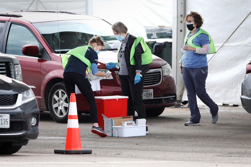 Health workers administer coronavirus vaccine shots at a drive-thru mass vaccine clinic at the Circuit of the Americas on Feb. 27.