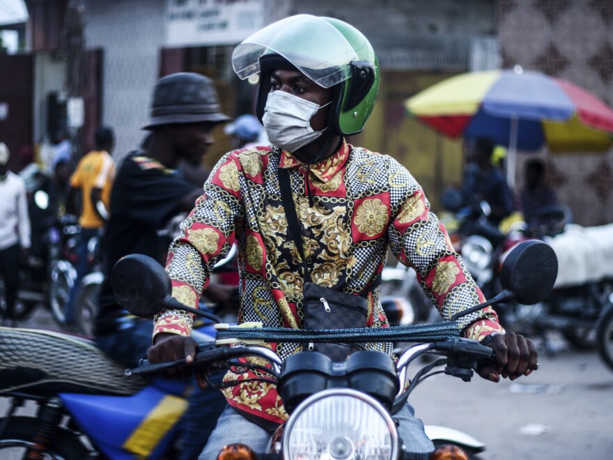 A masked motorcycle taxi driver in Kinshasha.