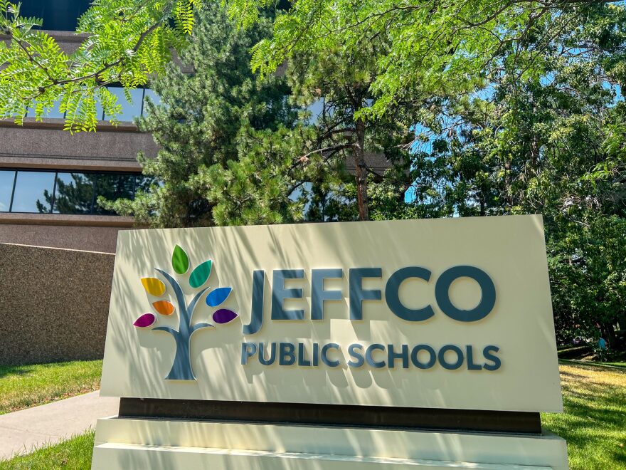 A photo outside of a building with a large sign that says "JeffCo Public Schools"