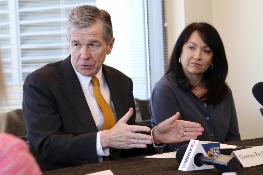 North Carolina Gov. Roy Cooper, left, and Planned Parenthood South Atlantic CEO Jenny Black speak with doctors at a forum about new abortion restrictions, Wednesday, May 10, 2023, at Cape Fear Community College in Wilmington, N.C.