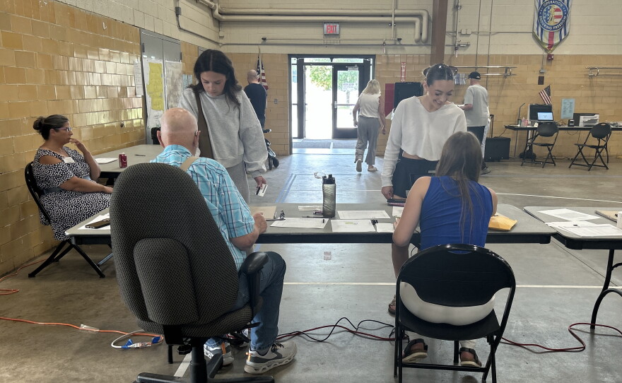 Two election judges greet voters at the Hibbing Precinct 1 polling location at the National Guard armory for the 2026 midterm primary on Aug. 11, 2026.