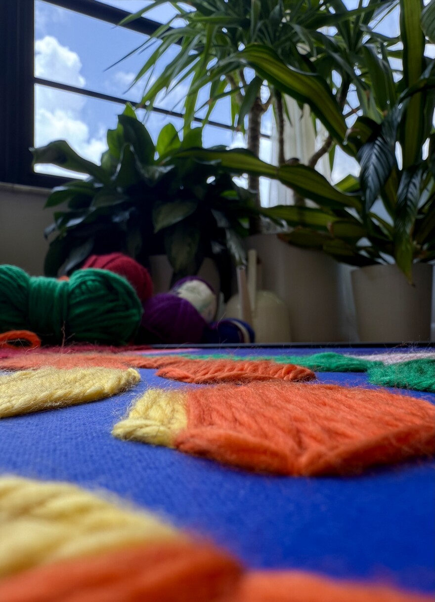 Harold Caudio displays some of the fabric used to create a hand-sewn yarn portrait of Coco Gauff — part of his Warri-Her project honoring women's strength. The title, a twist on “warrior,” marks a new phase in his empowerment-focused art. The piece will be unveiled at the Cornell Art Museum on July 19.