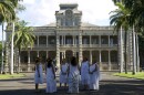 Women practice the mele, or musical chant, they will welcome marchers with as they enter through the gates of ʻIolani Palace.