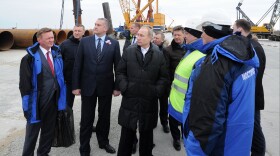 Russian President Vladimir Putin (center) joins Russia's federal highway agency head Roman Starovoit (left) and Crimean leader Sergei Aksyonov (second from left) on a visit to the Kerch Strait bridge construction site on Tuzla Island on March 18. The bridge will link Crimea to mainland Russia.