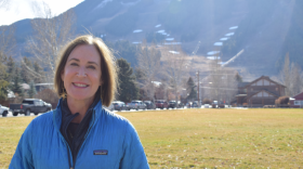 Photo of woman standing in front of ski hill