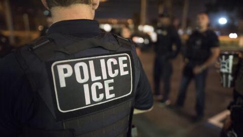 Person in dark blue with vest that reads Police ICE
