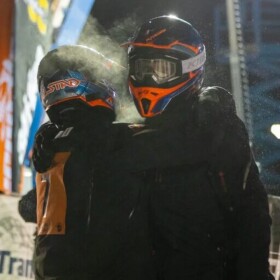 Tyler Aklestad and Nick Olstad embrace moments after crossing the finish line of the 2025 Iron Dog snowmachine race.