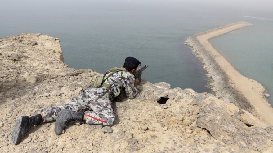 A member of the Iranian military takes position in a military exercise on the shore of the Sea of Oman in December.