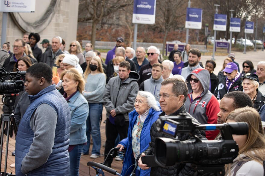 Near the University of Evansville Peace Bell, news media and attendees listen to the ceremony commemorating victims of the 1977 plane crash which included 14 UE basketball players.