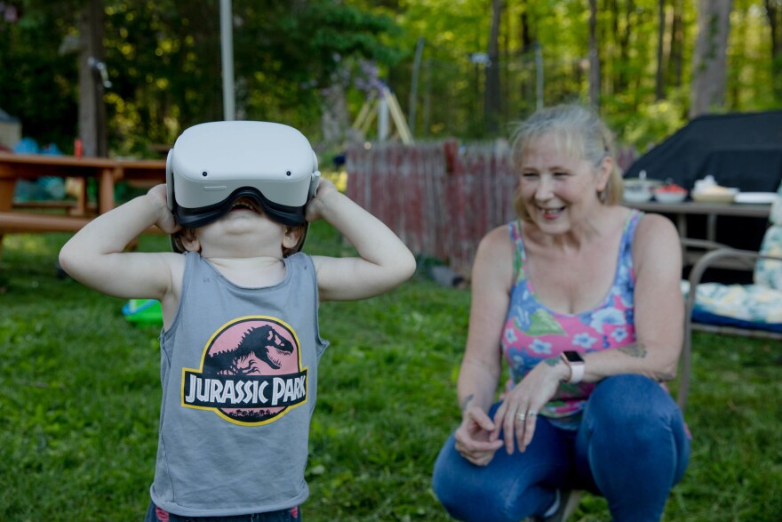 Linda Munson's youngest grandson, Daniel Gomez, 2, tries on an Oculus headset in her yard in Berlin, Conn. Playing different virtual reality games has become her family's regular Sunday activity, Munson said.