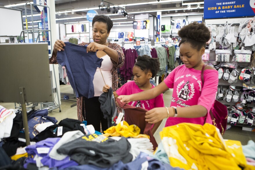 Ayeisha Owens, left, and her daughters Karisma Clark, center, and Kaiden Clark, right, shop for some last minute back-to-school clothes on Saturday, August 18, 2018. Ayeisha insisted that the girls buy clothes that were big enough to last them through next summer as well. She also kept an eye out for anything they could wear once the weather got colder.